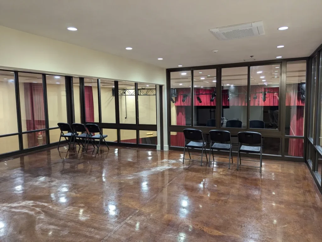 An upstairs meeting room with glass walls looking out over the auditorium